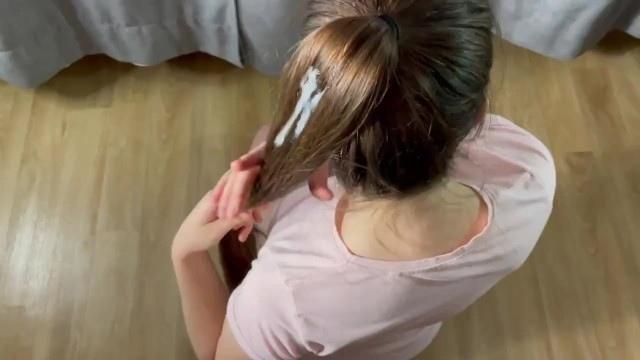 Девушка в футболке стоит на коленях перед другом и принимает на волосы его сперму
